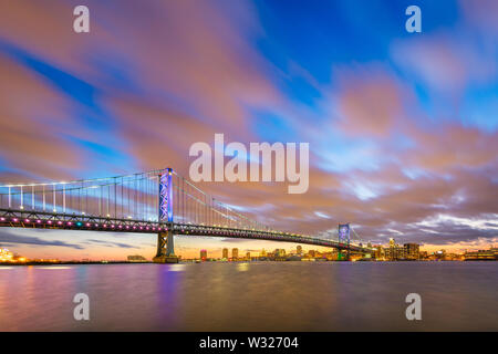 Philadelphia, Pennsylvania, USA Skyline auf dem Delaware River mit Ben Franklin Bridge bei Nacht. Stockfoto