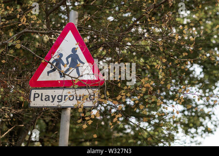 Spielplatz Kinder Crossing Road Sign in Großbritannien mit dem klassischen hellen roten Grenze gefunden. An einem sonnigen Tag Stockfoto