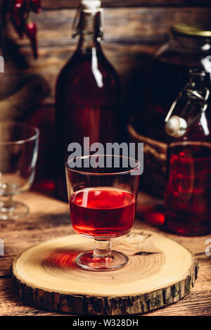 Hausgemachte berry nalewka Wein Glas auf Holz- fach Stockfoto