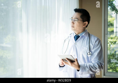 Asiatischer mann Arzt mit Tablet Computer im Krankenhaus. Stockfoto