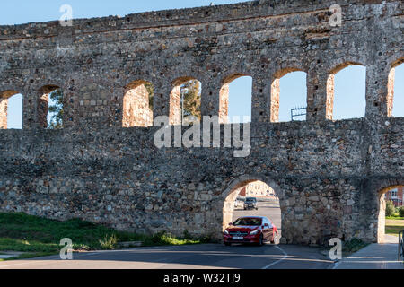 Alt trifft Neu: ein Auto fahren durch das Aquädukt de San Lazaro, einer alten römischen Aquädukt in Merida, Spanien Stockfoto