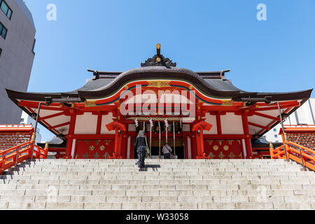 Tokyo, Japan - 4. April 2019: Hanazono Schrein Eingang mit Treppe Treppen in Shinjuku Station mit inari Tempel, Menschen zu Fuß att Cherry Blossom Flo Stockfoto