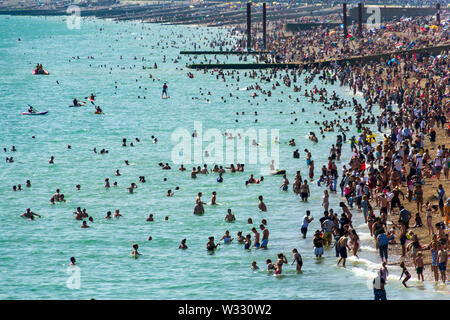 De Juni 29th, 2019 Strand von Brighton, Brighton und Hove, East Sussex, England. Tausende von Menschen auf der Sonnenterrasse entspannen. Stockfoto