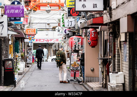 Tokyo, Japan - 1. April 2019: berühmte Goldene Gai Gasse Straße mit Japanischen pubs Izakaya, Restaurants in Shinjuku Stadt mit Menschen zu Fuß während des Tages Stockfoto