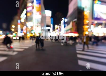 Defokussierten verschwommenen Hintergrund von Menschen crossing Crosswalk im Rotlichtviertel Kabukicho in Shinjuku, Tokyo Japan in der dunklen Nacht, Nachtleben