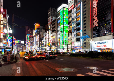 Shinjuku, Japan - April 4, 2019: Bunte Neon Lichter der Stadt mit Autos, Taxis und Leute, Gebäude, Wolkenkratzer, Shidax karaoke St Stockfoto
