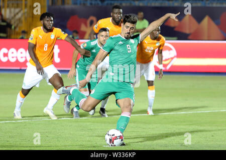 Suez. 11. Juli, 2019. Bagdad Bounedjah (Vorne) von Algerien tritt eine Strafe während der viertelfinalegleichen zwischen Côte d'Ivoire und Algerien am 2019 Afrika Cup der Nationen in Suez, Ägypten am 11. Juli 2019. Das Spiel endete 1-1 durch zusätzliche Zeit. Algerien beat Cote d'Ivoire 4-3 in einem Elfmeterschießen. Credit: Wang Teng/Xinhua/Alamy leben Nachrichten Stockfoto