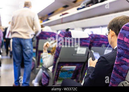 Tokio, Japan - April 4, 2019: Innerhalb der Hochgeschwindigkeitszug Shinkansen Auto in Shinjuku Bahnhof mit japanischen Geschäftsmann, sitzen auf Stühlen sitzen, mit Stockfoto