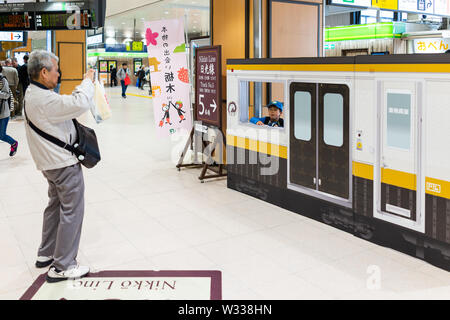 Tokio, Japan - April 4, 2019: Vater unter Foto von seinem Kind in Zug am JR-Bahnhof in der Präfektur Tochigi von Nikko con Stockfoto