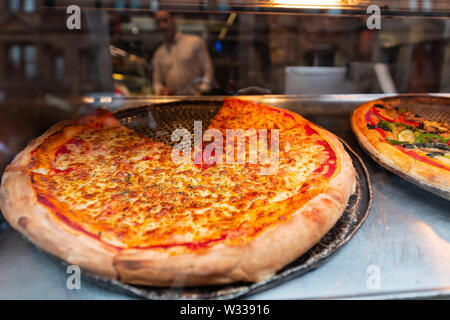 Nahaufnahme von frischen großen Kruste Pizza in Store Cafe auf Anzeige Restaurant in Italien mit geschmolzenem Mozzarella und schlichten Tomatensauce Schichten Stockfoto