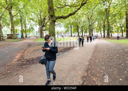 London, Großbritannien - 12 September 2018: Alley Pfad im Green Park in Westminster Stadt in Großbritannien mit Paar und Menschen zu Fuß Stockfoto
