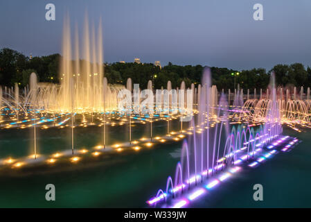 Bunt farbig beleuchtete singende Fontäne mit glatten Wasser auf dem Hintergrund der Nachthimmel im Tsaritsino Park in Moskau Stockfoto