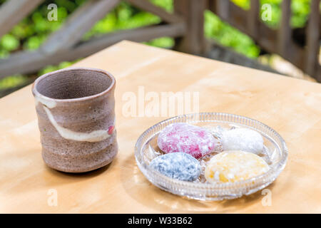 Grüner Tee mino Cup und mochi Reiskuchen japanische Dessert wagashi Bunte daifuku auf Holztisch mit bokeh Hintergrund Stockfoto