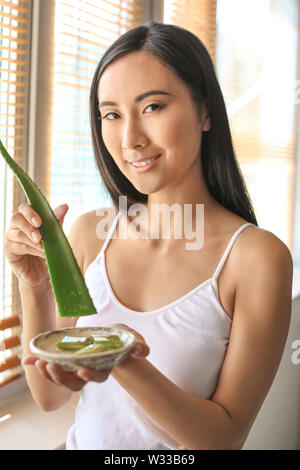 Schöne asiatische Frau mit Aloe vera zu Hause Stockfoto