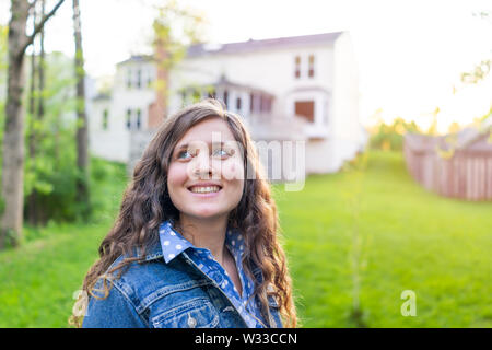 Junge Frau Mädchen lächelnd Eigenheimbesitzer in Herndon, Virginia, Fairfax County Wohngegend im Frühjahr oder Sommer Haus und Garten gerne Stockfoto