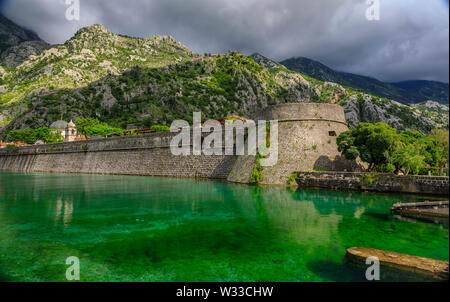 Smaragdgrüne Wasser der Bucht von Kotor oder Boka Kotorska, Berge und das alte steinerne Stadtmauer von Kotor ehemalige venezianische Festung in Montenegro Stockfoto