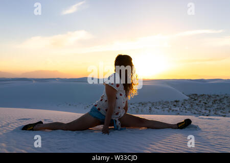 Frau Mädchen trainieren tun Splits Übung in White Sands Dunes National Monument in New Mexico Sonnenuntergang Stockfoto