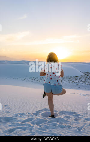 Frau zurück Ausübung auf ein Bein in White Sands Dunes National Monument in New Mexico Sonnenuntergang Stockfoto