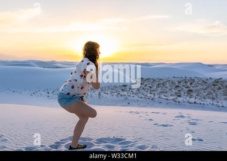 Frau Ausübung auf ein Bein in White Sands Dunes National Monument in New Mexico Sonnenuntergang Stockfoto