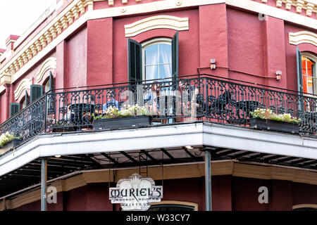 New Orleans, USA - 22. April 2018: Leute Paar an Muriel's Jackson Square Bistro Restaurant im Gusseisen, Schmiedeeisen Gebäude Balkon in Louisia Stockfoto