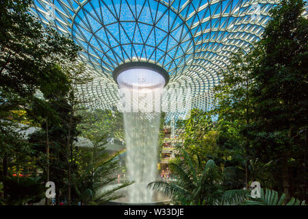 Landschaft Innenansicht von Jewel Changi Airport mit blauem Himmel und Regenbogen, es gibt auch eine Skytrain in der wieder mit dem Track, Singapur Stockfoto