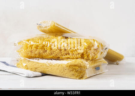 Verschiedene Pasta in transparenten Plastikbeuteln auf einem Küchentisch. Lebensmittel. Spaghetti, Fusilli und Vermicelli. Stockfoto