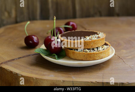 Schoko Törtchen mit Beeren und Nüssen Stockfoto