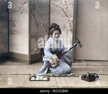 [1890s Japan - Geisha spielen die Shamisen] - eine Frau, die das Üben der Shamisen. 19 Vintage albumen Foto. Stockfoto