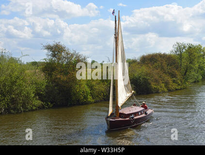 Altmodische Yacht unter Segeln navigieren im Fluss in der Nähe von Bure Horning, die Norfolk Broads. Stockfoto