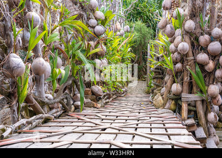Eine Mauer des alten Kokosnüsse und eine hölzerne Brücke an einem tropischen Strand im Paradies Insel Koh Phangan, Thailand. Travel Concept Stockfoto