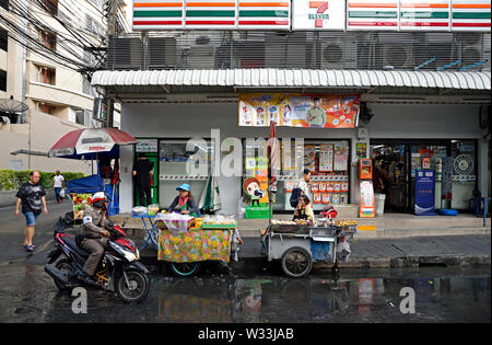 Bangkok, Thailand - 17. Januar 2019: imbissstände vor einem 7 Eleven laden an der Sukhumvit Soi 1, Polizist auf Motorrad Stockfoto