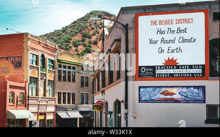 "Bisbee Bezirk hat das beste Jahr, das Klima auf der Erde' liest ein Zeichen auf einer alten Mauer mit einem vorberg Kulisse, in Bisbee, AZ lackiert Stockfoto