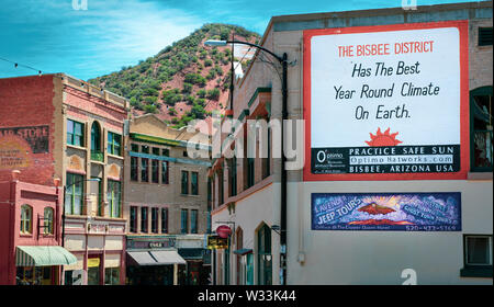 "Bisbee Bezirk hat das beste Jahr, das Klima auf der Erde' liest ein Zeichen auf einer alten Mauer mit einem vorberg Kulisse, in Bisbee, AZ lackiert Stockfoto