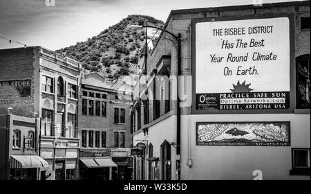 "Bisbee Bezirk hat das beste Jahr, das Klima auf der Erde' liest ein Zeichen auf einer alten Mauer mit einem vorberg Kulisse, in Bisbee, AZ lackiert Stockfoto