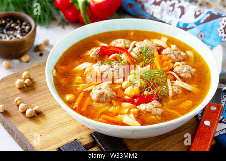 Hausgemachte heiße Suppe mit Pasta, Türkei Frikadellen und Erbsen Kichererbsen. Östliche Küche. Das Konzept der gesunden Ernährung. Stockfoto