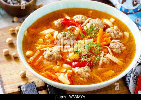 Hausgemachte heiße Suppe close-up mit Pasta, Türkei Frikadellen und Erbsen Kichererbsen. Östliche Küche. Das Konzept der gesunden Ernährung. Stockfoto