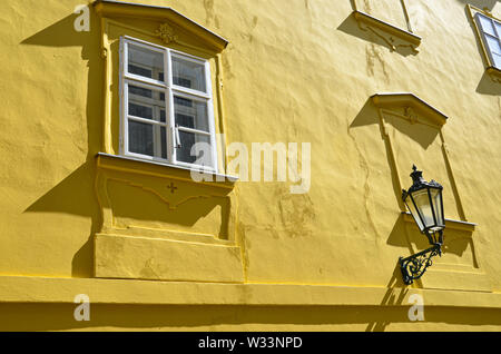 Detail der gelben Fassade der historischen Gebäude in der Altstadt von Prag, tschechische Republik. Goldene stunde Fotografie. Sonne auf der Fassade. Straßenlaterne. Art.Praga, Tschechien, Europa. Stockfoto