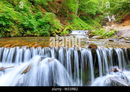 Tagsüber weiches Licht im Wald leuchtet das klare Wasser einer mountain river in einer Kaskade Wasserfall in den Karpaten vor dem Hintergrund der b Stockfoto