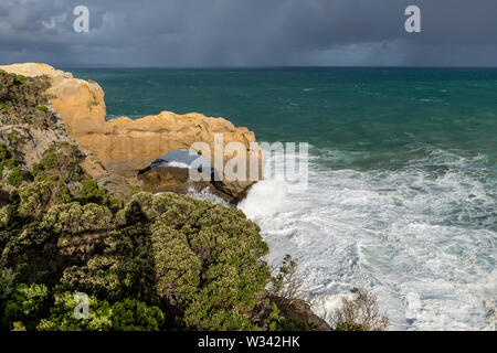 Schönen Blick auf den Arch Rock entlang der Great Ocean Road, Australien, mit einem stürmischen Himmel im Hintergrund Stockfoto