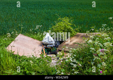 Fliegenkippen von Haushaltsabfällen auf einem Bauernfeld auf dem Land in Großbritannien. Stockfoto