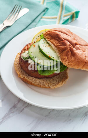 Erfahrene Fisch Kuchen Sandwich auf eine ganze Weizen Hamburger Brötchen mit cremigen Sauce Tartar Stockfoto
