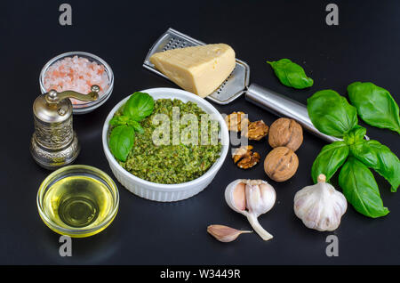 Zutaten für die Herstellung von Pesto mit Walnuss auf schwarzem Hintergrund Stockfoto