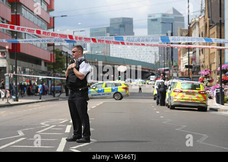 Ein Polizist am Tatort ein Stechen auf Barking Road, Newham, East London. Polizei bei ca. 0740 am Freitag Morgen auf Berichte über einen Stechenden und ein Mann, genannt wurden, geglaubt, in seinem 20s zu sein, wurde zu einer East London Krankenhaus für die Behandlung genommen. Stockfoto