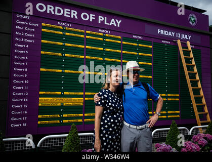 Zuschauer posieren für ein Foto vor der Bestellung des Spiels am Tag elf der Wimbledon Championships in der All England Lawn Tennis und Croquet Club, Wimbledon. Stockfoto