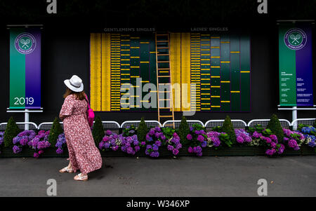 Zuschauer posieren für ein Foto vor der Bestellung des Spiels am Tag elf der Wimbledon Championships in der All England Lawn Tennis und Croquet Club, Wimbledon. Stockfoto