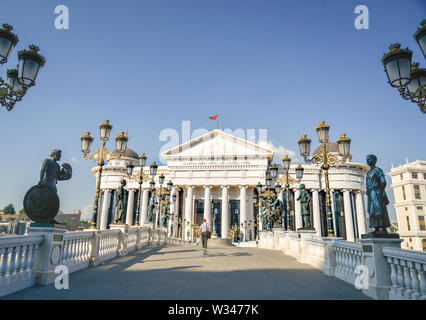 SKOPJE, MAZEDONIEN - 23. AUGUST 2019: Mann über die Brücke zu den Archäologischen Museum von Mazedonien. Stockfoto