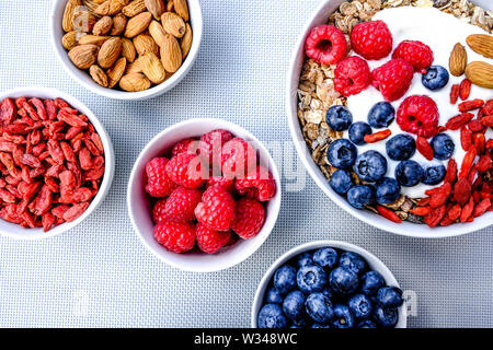 Gesunde vegetarische Frühstück Schüssel Müsli mit frischem Obst und Joghurt in weißen Schalen Stockfoto