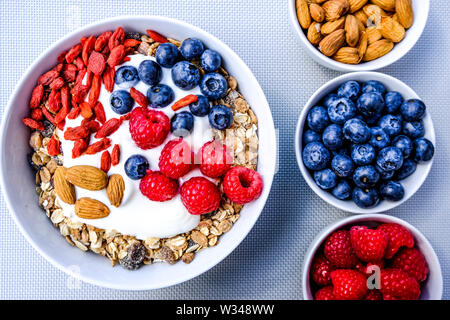 Gesunde vegetarische Frühstück Schüssel Müsli mit frischem Obst und Joghurt in weißen Schalen Stockfoto