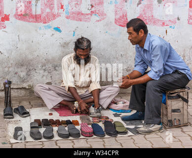 Der Mensch hat seinen Schuh auf einer Straße in Kathmandu repariert Stockfoto