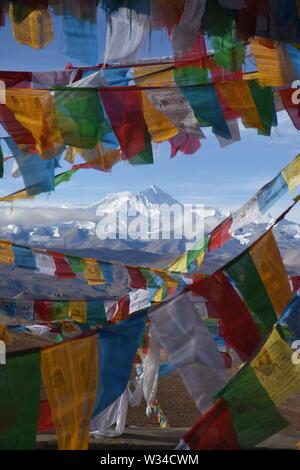 Mount Everest mit Gebetsfahnen im Vordergrund. Aus Tibet genommen, ist der atemberaubende Berg unter einem klaren blauen Himmel zu sehen. Stockfoto